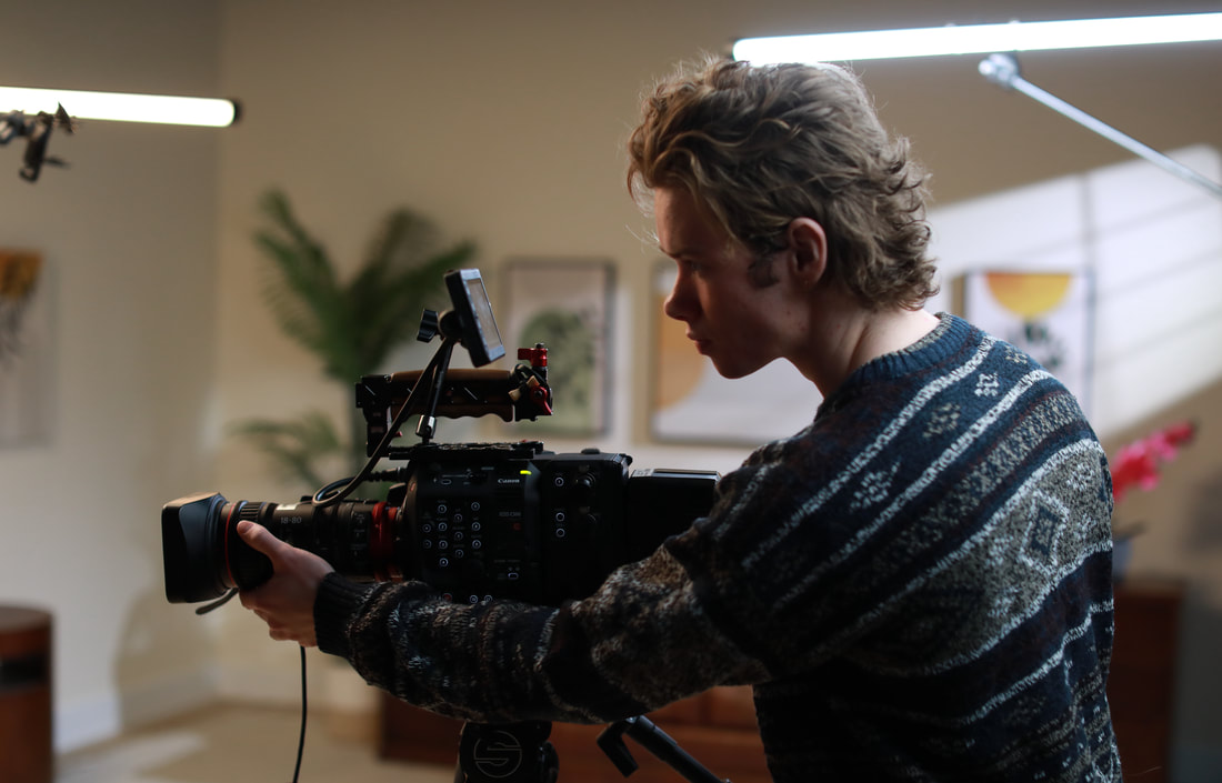 Wilson McMillan filming with a camera on a tripod